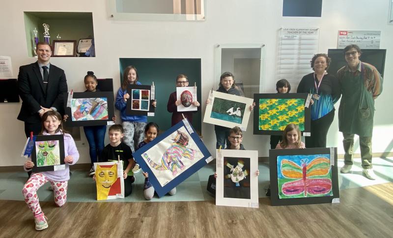 Love Creek Elementary Young at Art participants and supporters in back are (l-r) Assistant Principal James McDowell, Amaiya Person, Penny Stewart, Jack Hudson, Colton Pusey, Lorenzo Duffy, Principal Lisa Morris and art teacher Forest Allread. In front are Beall Flynn, Connor Benson, Navya Desai, Ryan Reay and Everleigh Thompson. ELLEN DRISCOLL PHOTO